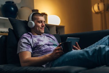 Bir adam akşamleyin kanepede film izliyor..