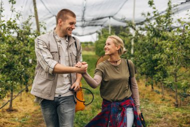Meyve bahçesindeki iki işçi işlerini bitirdikten sonra mutlu olurlar..