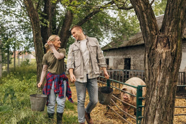 stock image Young couple in love work together on an animal farm on countryside.