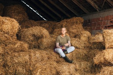 Samanlıkların arasında oturan bir kadının ön görüntüsü..