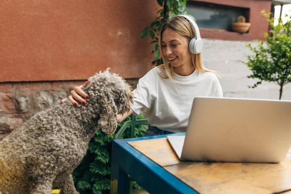 Beyaz bir kadın arka bahçede köpeğine sarılıyor..