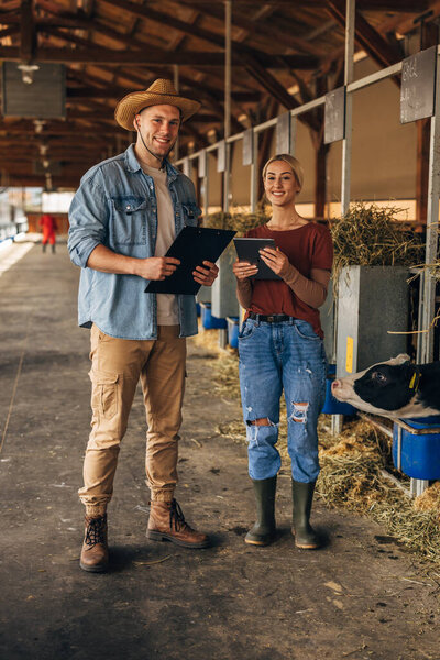Two attractive young people working at the farm in a countryside