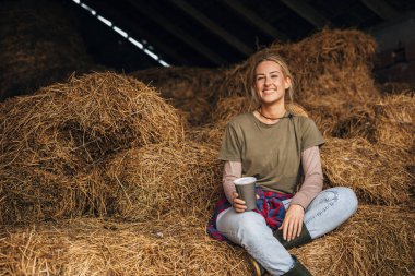 Samanlıkta oturan mutlu bir kadın..