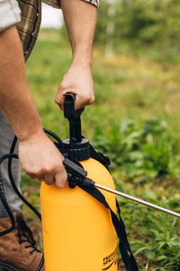Çiftçilerin el ele tutuşup bahçeye kimyasal madde sıktıklarını görüyoruz..