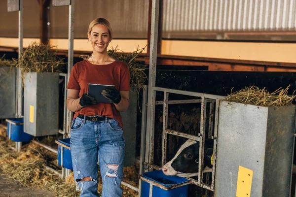A beautiful happy woman works at the animal farm.