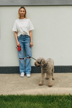 Mutlu bir kadın köpeğini gezdirir..