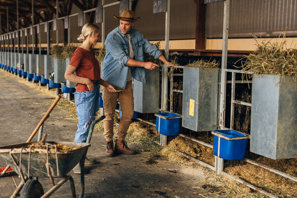 A man and a woman work at the animal farm.