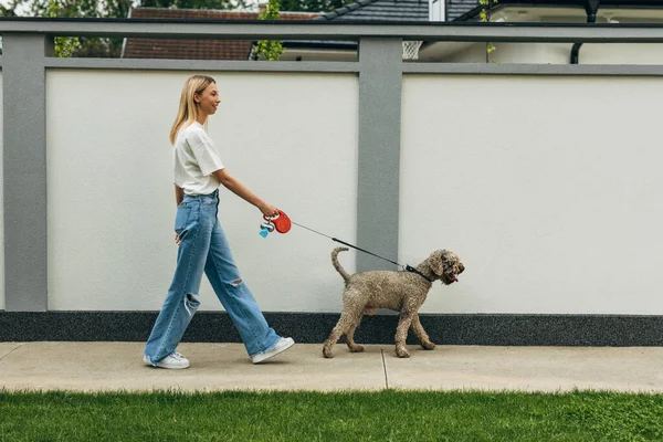 Sidovy Över Blond Kvinna Som Tar Hunden Promenad — Stockfoto