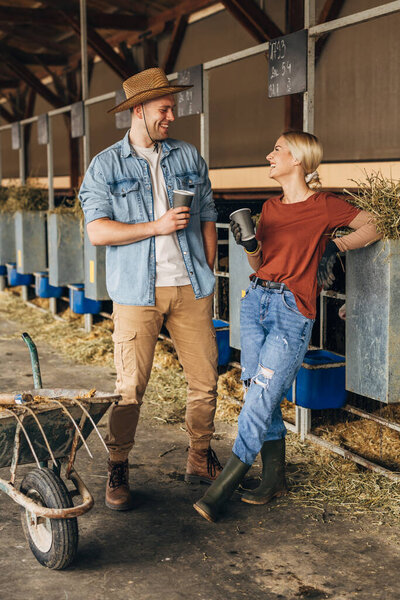 Two happy Caucasian people flirting in a barn.