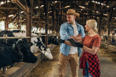 Köylüler dijital tabletle bir ahırda duruyorlar..