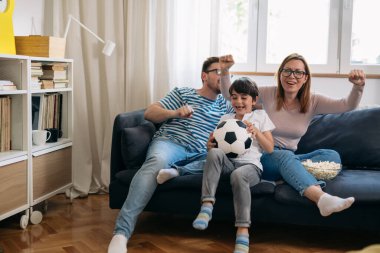Beyaz bir aile birlikte futbol maçı izleyip tezahürat yapıyor..