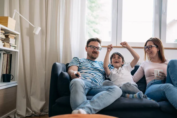 Stock image Family watches sports together and son cheers.