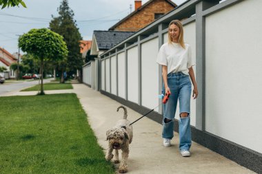 Mahallede köpeği gezdiren genç ve güzel bir kadın..