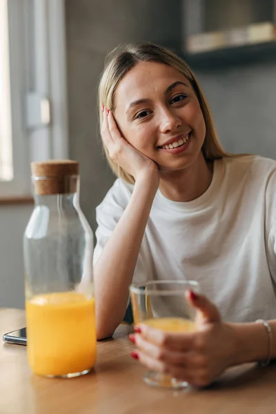 一个美丽快乐的女人喝橙汁的画像 — 图库照片