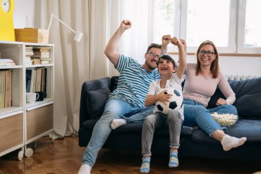 Bir futbol maçı izlerken mutlu beyaz aile tezahüratı.