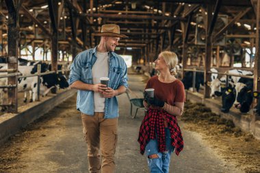 Ahırda yürüyen ve konuşan bir kadınla bir adamın ön görüntüsü..