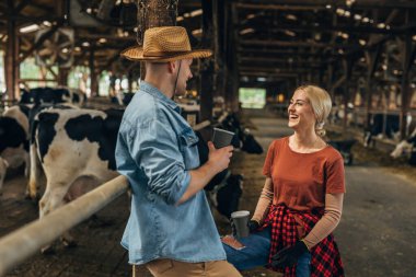 Kadın ve erkek çiftçi, hayvan çiftliğinde birlikte çalışmaktan zevk alıyor..