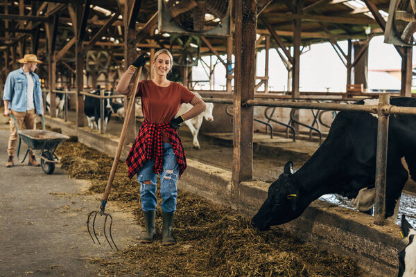 Красивая ковбойша работает в конюшне.