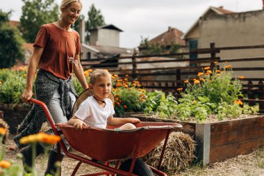 Çocuğunu arabaya iten bir annenin yan görüntüsü..
