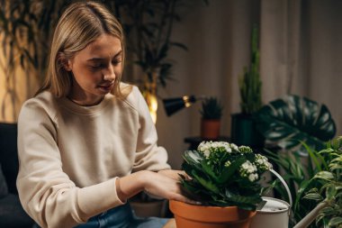 Kafkasyalı genç bir kadın saksı dikiyor..