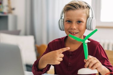 Genç bir öğrenci gururla yaptığı yel değirmeni modelini gösteriyor..