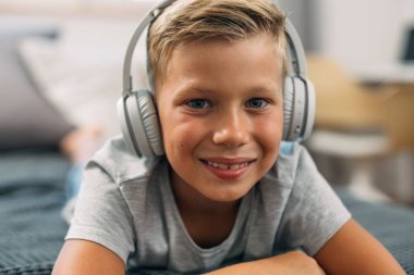 Kulaklıklı sevimli bir çocuğun yakın görüntüsü..