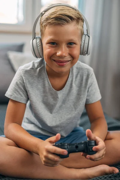 Młody Chłopiec Joystickiem Słuchawkami Patrzy Kamerę — Zdjęcie stockowe