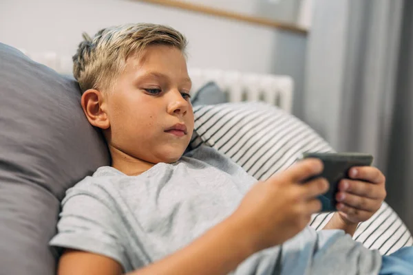 Ein Kaukasischer Junge Liegt Bett Und Benutzt Sein Smartphone — Stockfoto