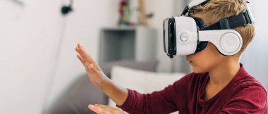 Sanal gerçeklik kulaklığı kullanan bir çocuğun yan görüntüsü.