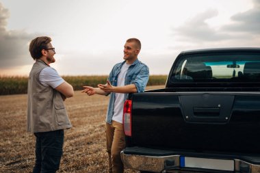 İki adam tarlada dikilip konuşuyor..