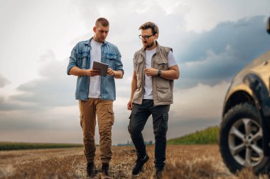 Tarlada yürüyen ve konuşan iki işadamının ön görüntüsü..