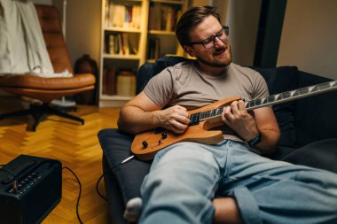 Kafkasyalı bir adam elektro gitarla yaptığı melodi şapkasının tadını çıkarıyor..