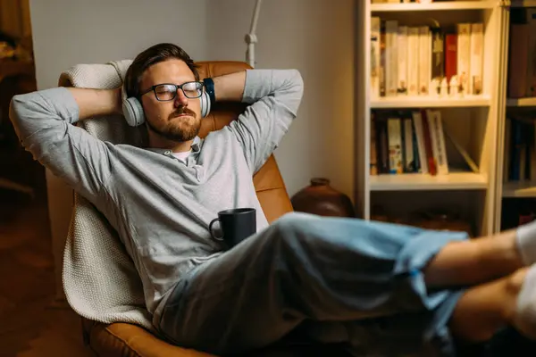 Caucasian man relaxes at home with music after a long day at work.