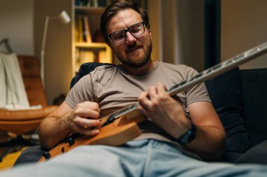 Evde gitar çalan tutkulu bir müzisyen..
