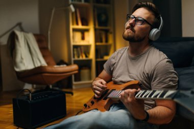 Müzisyen evde tek başına gitar çalmaktan hoşlanır..