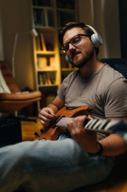 Müzisyen gözleri kapalı gitar çalarken gülümser..