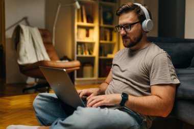 Orta yaşlı, beyaz bir adam evde çalışıyor..