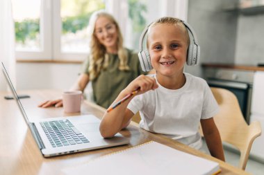 Kameraya bakarak öğrenmeye hevesli mutlu bir ilkokul öğrencisi.