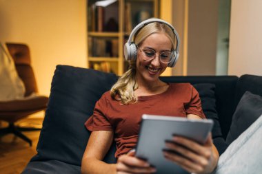 Güzel genç bir kadın tablet kullanarak bir video görüşmesi yapıyor..