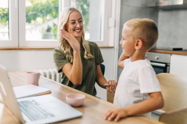 Destekleyici anne küçük oğluna beşlik çakıyor..
