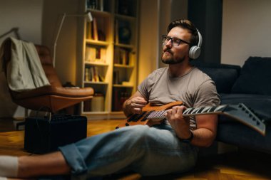 Huzurlu müzisyen elektro gitarla bir şarkı çalar.