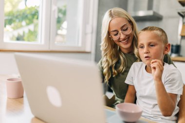 Güzel anne oğluyla mutfakta oturuyor ve birlikte film izliyor..