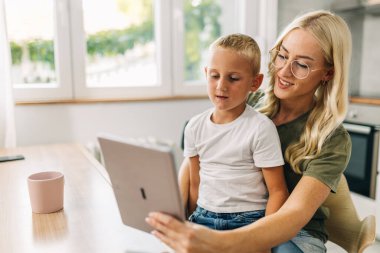 Anne ve oğlu dijital tablet kullanıyorlar..