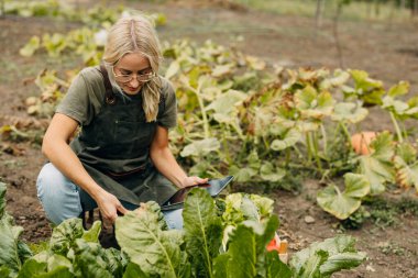 Bahçede çalışan bir kadının ön görüntüsü.