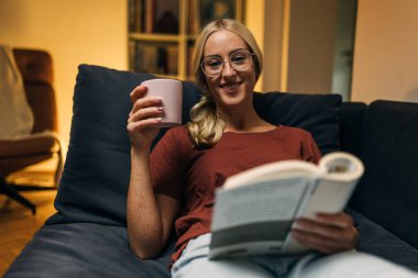 Huzurlu bir ortamda kitap okuyan bir kadının ön görüntüsü.