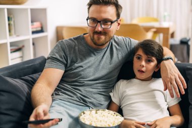 Baba ve oğul televizyonda film izliyorlar..