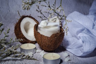 Cocoa oil and fresh coconuts on a light background