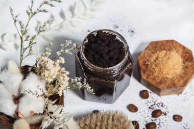 top view of ground coffee body scrub and what's in the glass jar