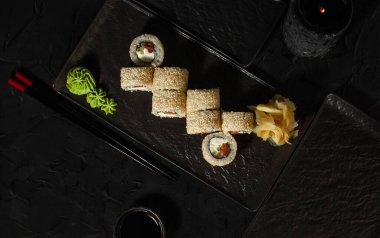 Ton balığıyla siyah şist üzerinde yuvarlan. Japon yemeği.