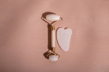 Beyaz doğal yeşim taşıyla yüz silindirli masaj. Masaj aleti, güzellik için de sümsük. Evde yaşlanma ve kaldırma etkisi. Yüz bakımı cihazı ve rahatlama konsepti.